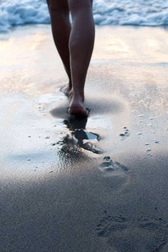Голая девушка босиком на песке 