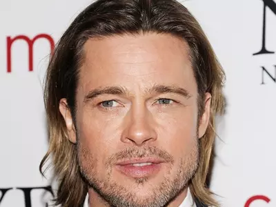 Brad Pitt trips while carrying daughter