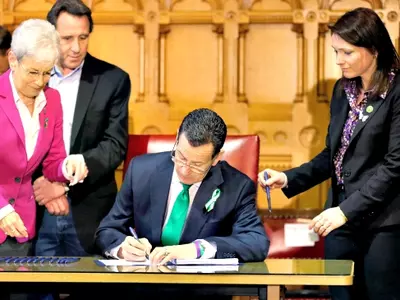 Connecticut Governor Dannel P Malloy signs legislation at the Capitol in Hartford, Connecticut, that includes new restrictions on weapons and large capacity ammunition magazines