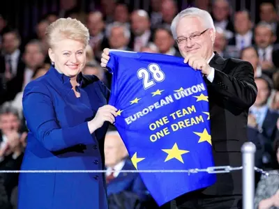 Croatia's President Josipovic holds a shirt he received from Lithuania's President Grybauskaite
