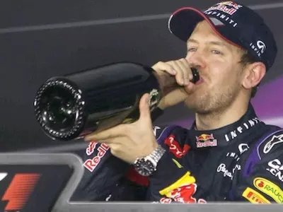 Red Bull driver Sebastian Vettel drinks champagne during a press conference after winning the Indian Formula One Grand Prix at Buddh International Circuit