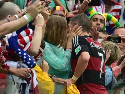 Germany's midfielder Bastian Schweinsteiger (R) kisses his girlfriend Sarah Brandner after a Group G football match between US and Germany at the Pernambuco Arena in Recife during the 2014 FIFA World Cup