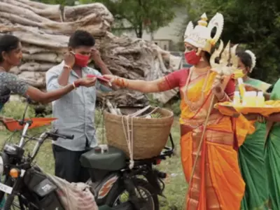 Woman dressed as goodess distribute masks