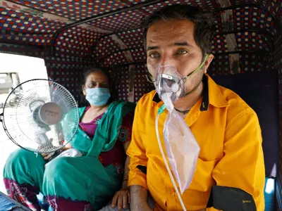 Covid-19 patient taking oxygen inside auto rickshaw