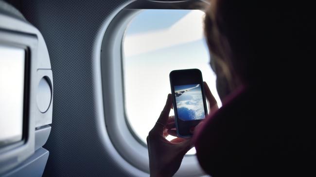 Woman using phone in flight