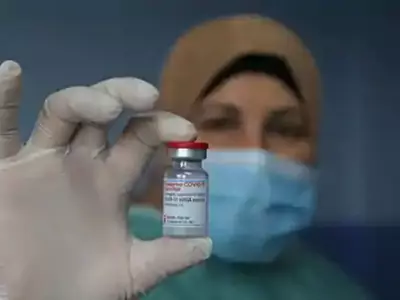 Palestinian health worker holds a vial of Covid-19 vaccine