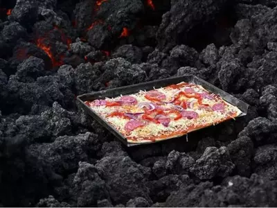 In the video he can be seen spreading the dough in the tray, adding tomato sauce and cheese and keeping it for baking on the volcano ashes. Some time into it and voila, the pizza is ready.