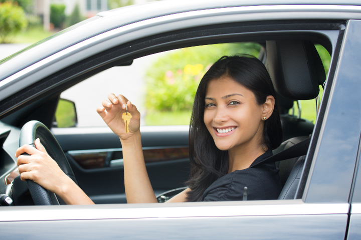 woman happy in car with key