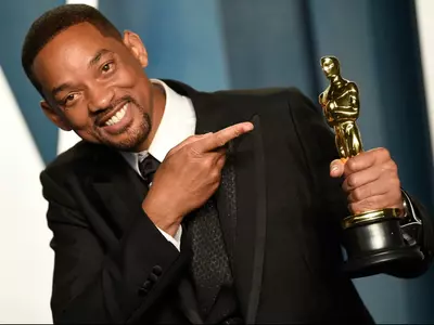 A photo of Will Smith posing with the Oscar trophy.