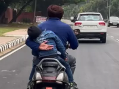 Man Holds Baby On Scooter 