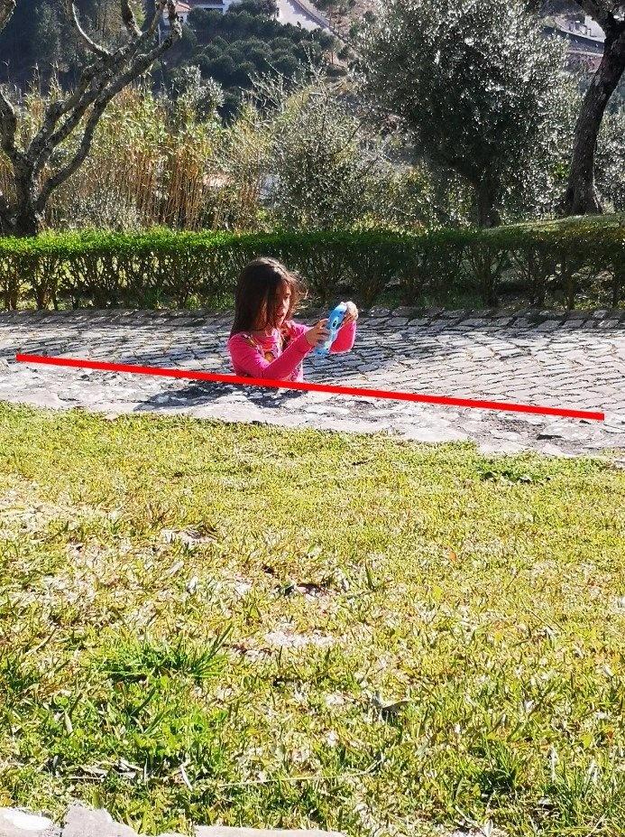 The girl is not buried and instead just appears to be as her bottom half has been cut off by a brick wall which blends perfectly with the pavement.
