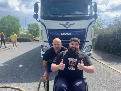 wheelchair bound man pulls two 10 tonne trucks