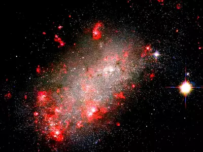 Galaxy With A Strange Shape And Red Star Blossoms Captured By Hubble Telescope