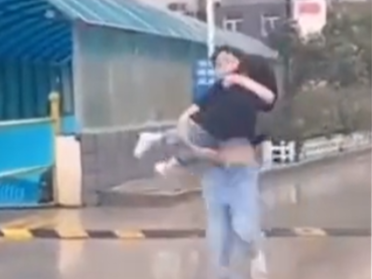 Big Brother Protects Little Sister From Rain In Viral Video