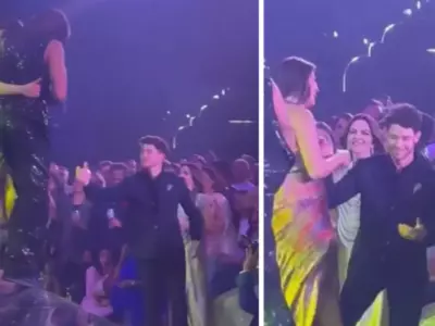 Nick Jonas Receiving Priyanka Chopra From Stage, Fixing Her Dress