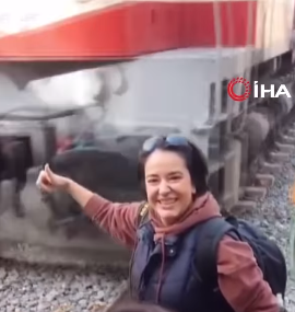 In front of a moving train, a woman almost loses her arm while taking a selfie