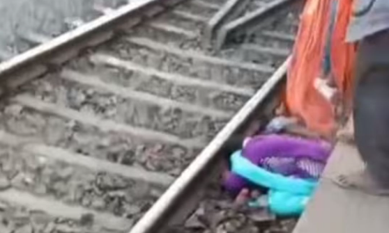 The train passes over a woman from Bihar and her two children, causing them to miraculously escape