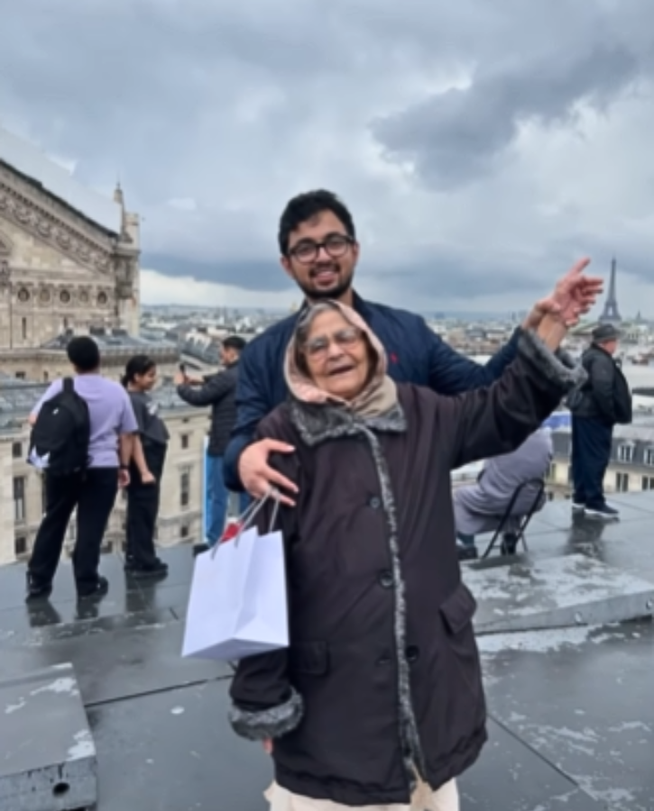 grandma stands in front of the eiffel tower