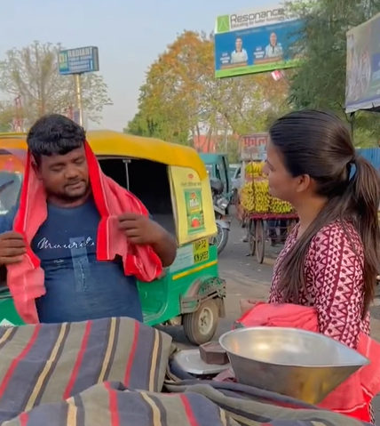Woman hands out Gamcha to street vendor
