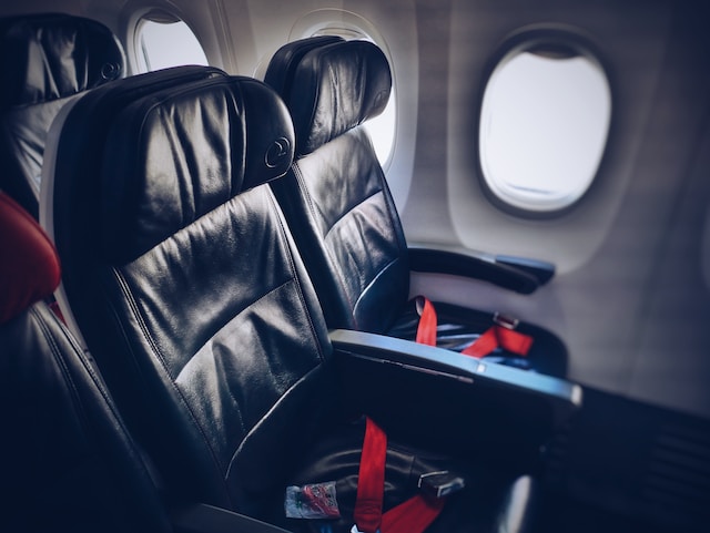 A flight attendant reveals the button to place the armrest in flight