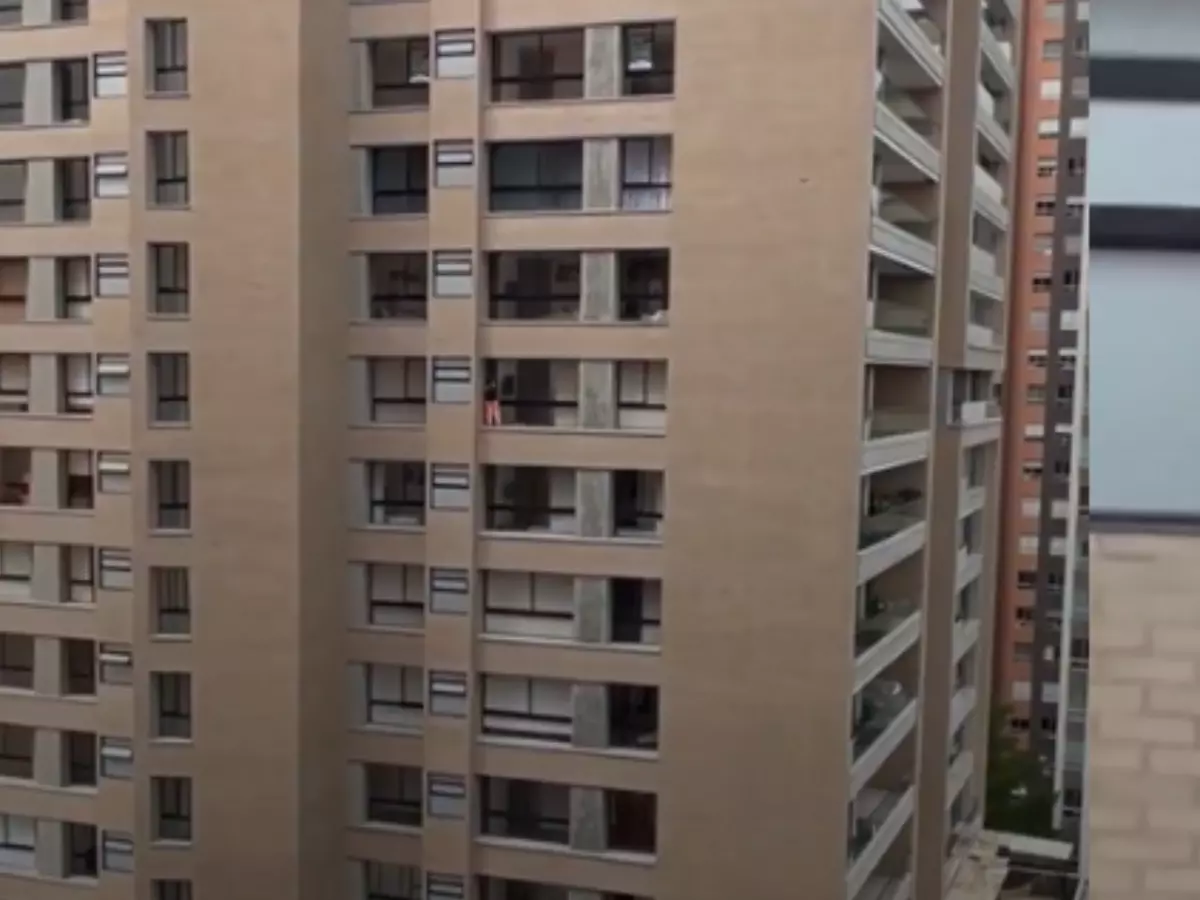 Woman Cleaning Window Of High-Rise Building