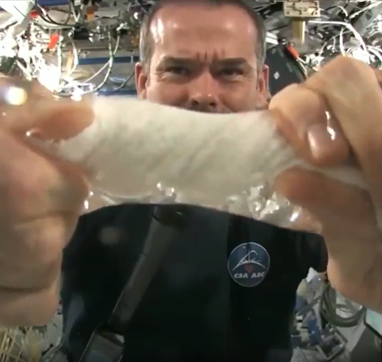 Astronaut wrings out a wet towel in space