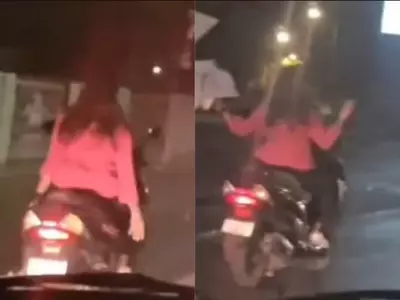 The Woman Goes Hands-free On A Busy Road While Riding Her Scooter
