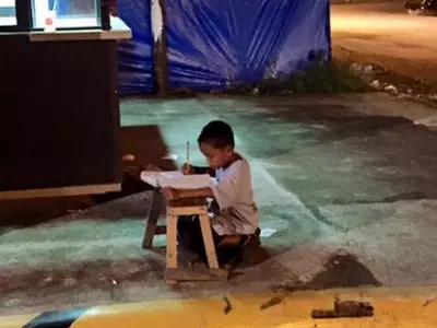 Kid studying under a streetlight