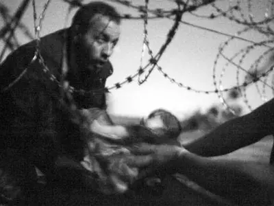 This Picture Of A Refugee Baby Passing Under A Barbed Wire Wins 'World's Best Photo' Award