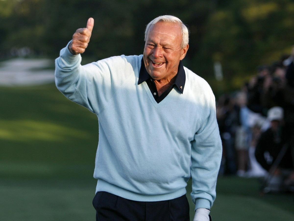 Golfing legend Arnold Palmer, right, signs the back of fellow