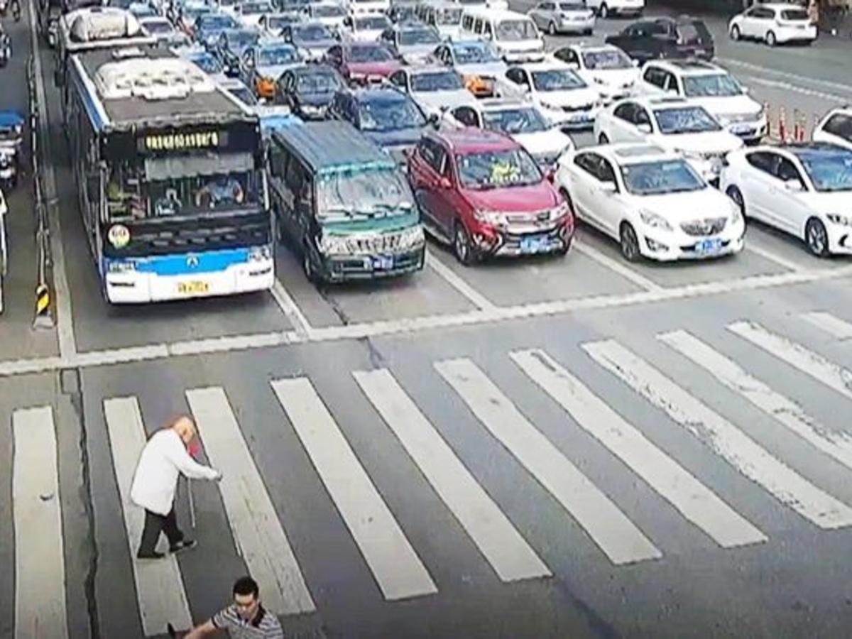 Man on mobile phone cross the road at a pedestrian crossing. Ho