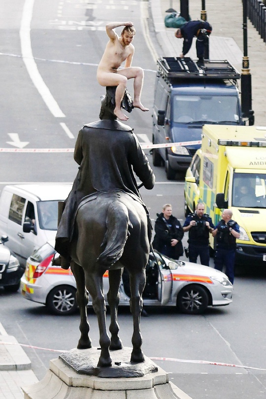 Naked man on top of the statue of Prince George