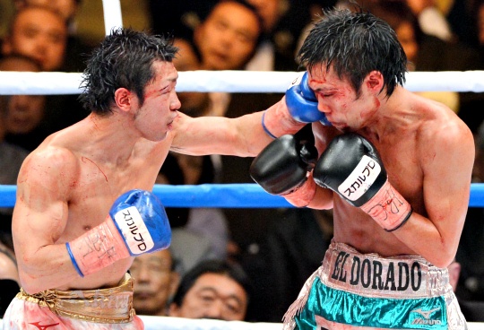Challenger Akira Yaegashi of Japan (L) punches defending champion Toshiyuki Igarashi of Japan (R) during their World Boxing Council (WBC) flyweight title bout in Tokyo