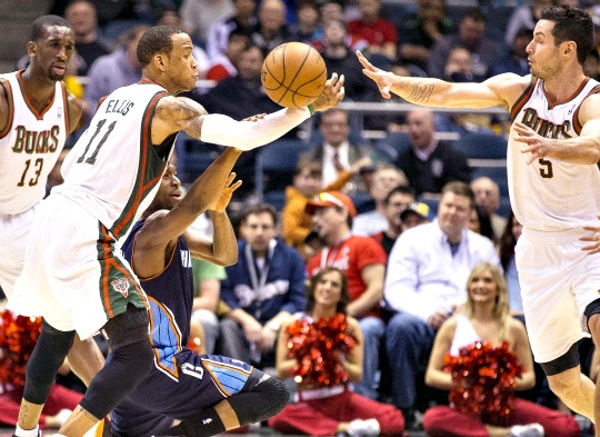 Milwaukee Bucks' Monta Ellis makes a steal in to the hands of teammate J.J. Redick as Charlotte Bobcats' Kemba Walker tries to grab the ball 