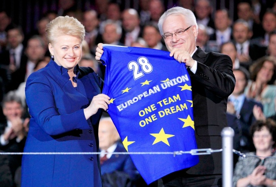 Croatia's President Josipovic holds a shirt he received from Lithuania's President Grybauskaite