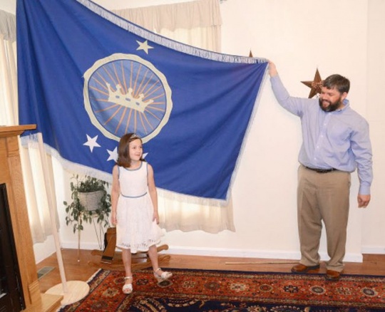 Jeremiah Heaton and his seven year-old daughter, Princess Emily, show the flag