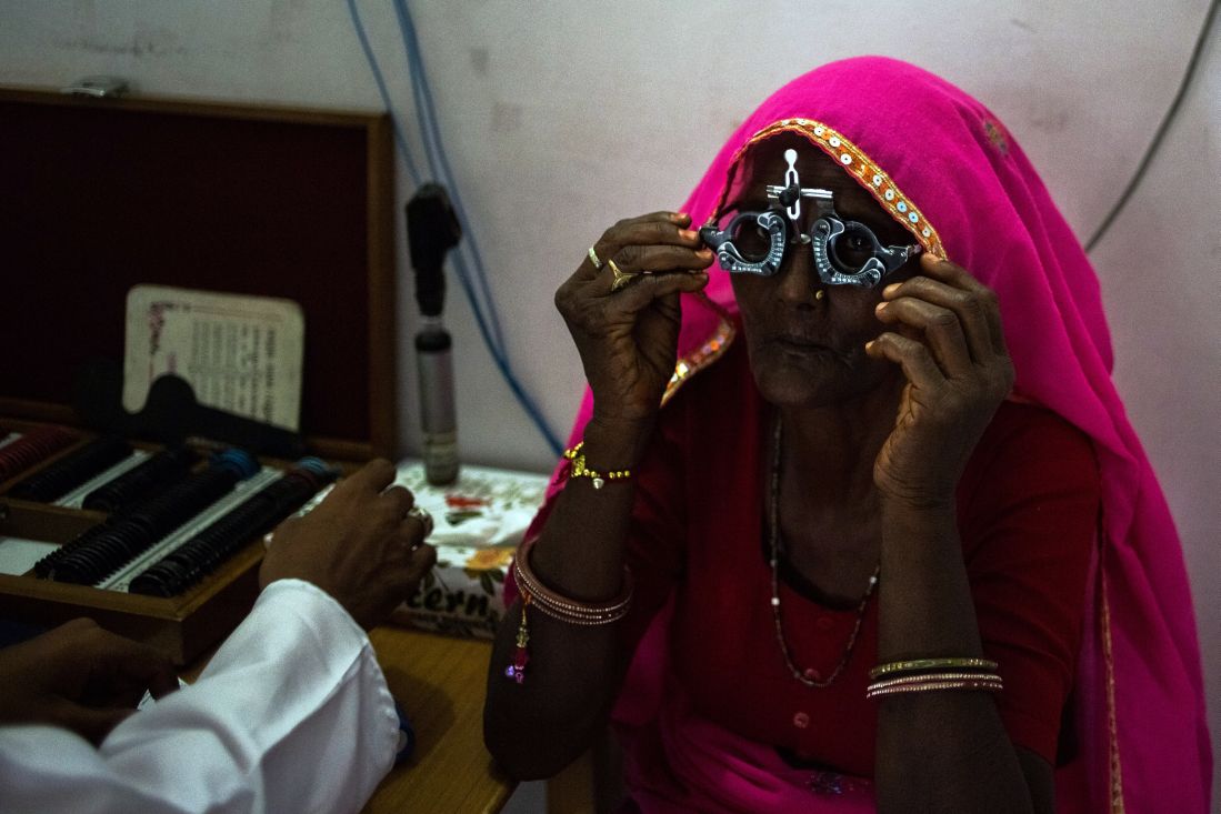 patient adjusts a pair of glasses used to test eyesight during an examination