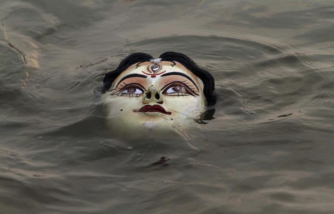 An idol of Hindu goddess Durga floats in water