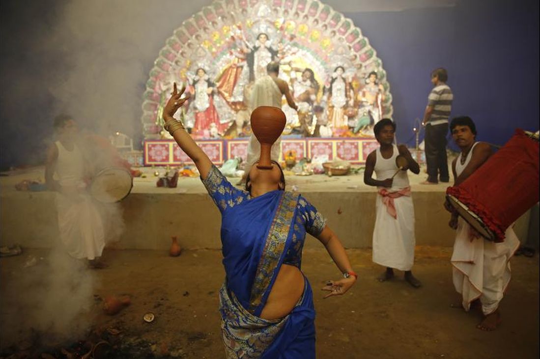A devotee performs a traditional Dhunuchi dance