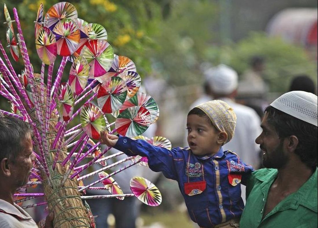 A buys a paper fly-wheel during the celebrations to mark Eid al-Adha