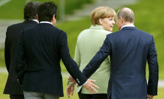  Japan's Prime Minister Shinzo Abe touches hands with Russia's President Vladimir Putin as they walk with Germany's Chancellor Angela Merkel