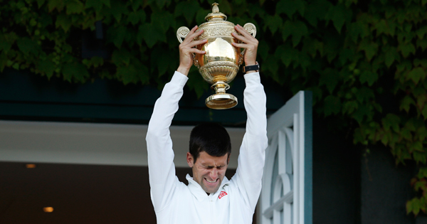 Champions proudly display the trophy on the Centre Court balcony.