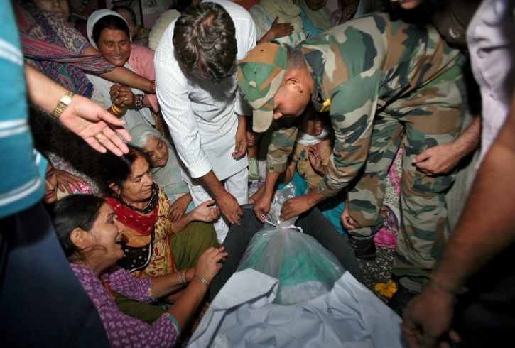 An Indian army soldier opens the body bag containing the body of his colleague Sat Pal Bhasin.