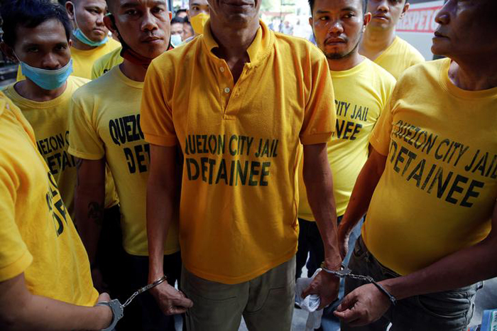 Inmates are handcuffed to each other as they are brought back from hearings to Quezon City Jail in Manila, Philippines