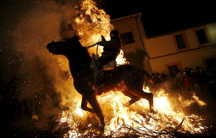 A man rides a horse through the flames