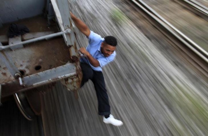 A Man clings to a freight train