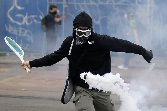 protestor uses a tennis racket
