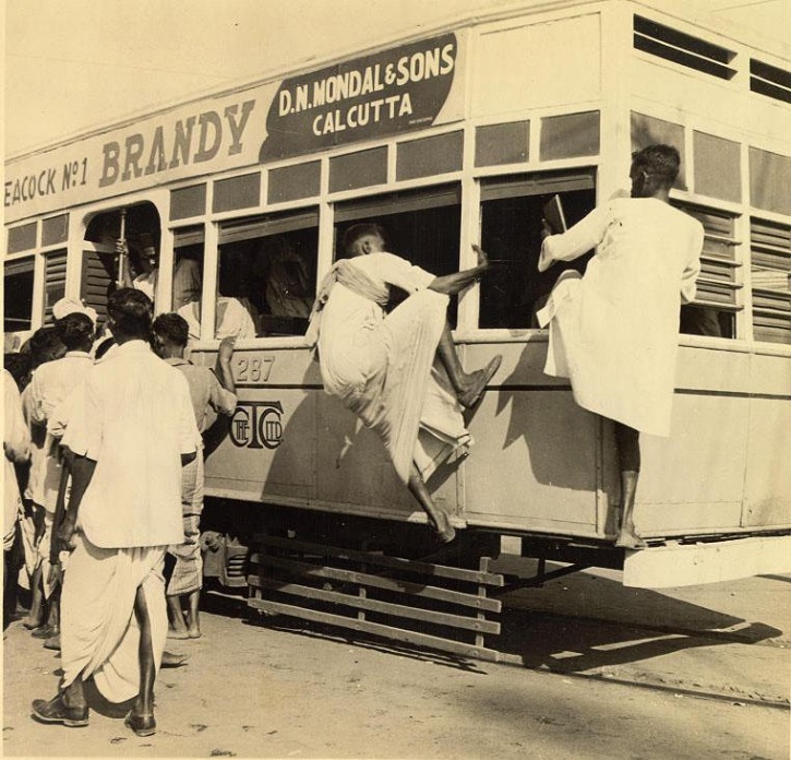 Shepherds herd their goats as a tram passes in the background at the  ´Maidan´ (open ground) in Kolkata (Calcutta), West Bengal, India. Started  by the  - SuperStock