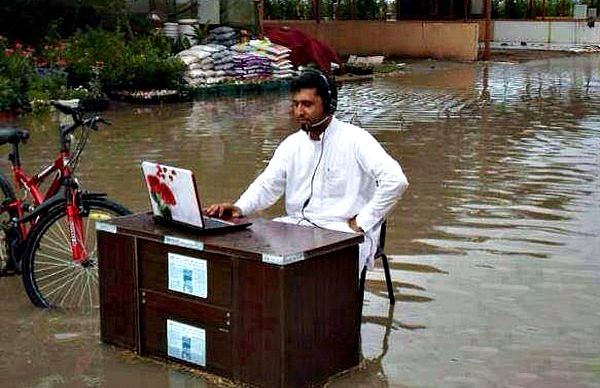man using laptop in floods