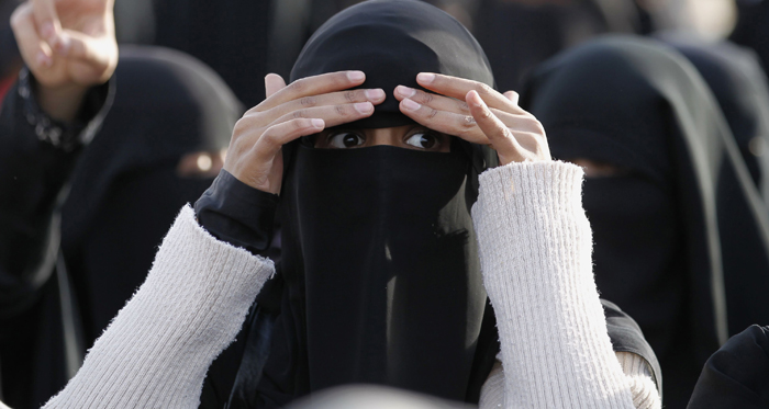 Placards identify burqa-clad
